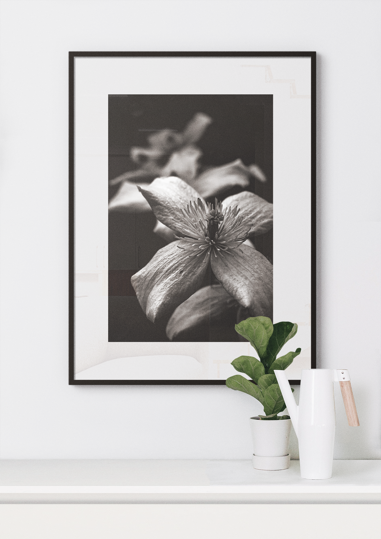 Macro nature print in glass with a thin black frame. Small plant and kettle below. 